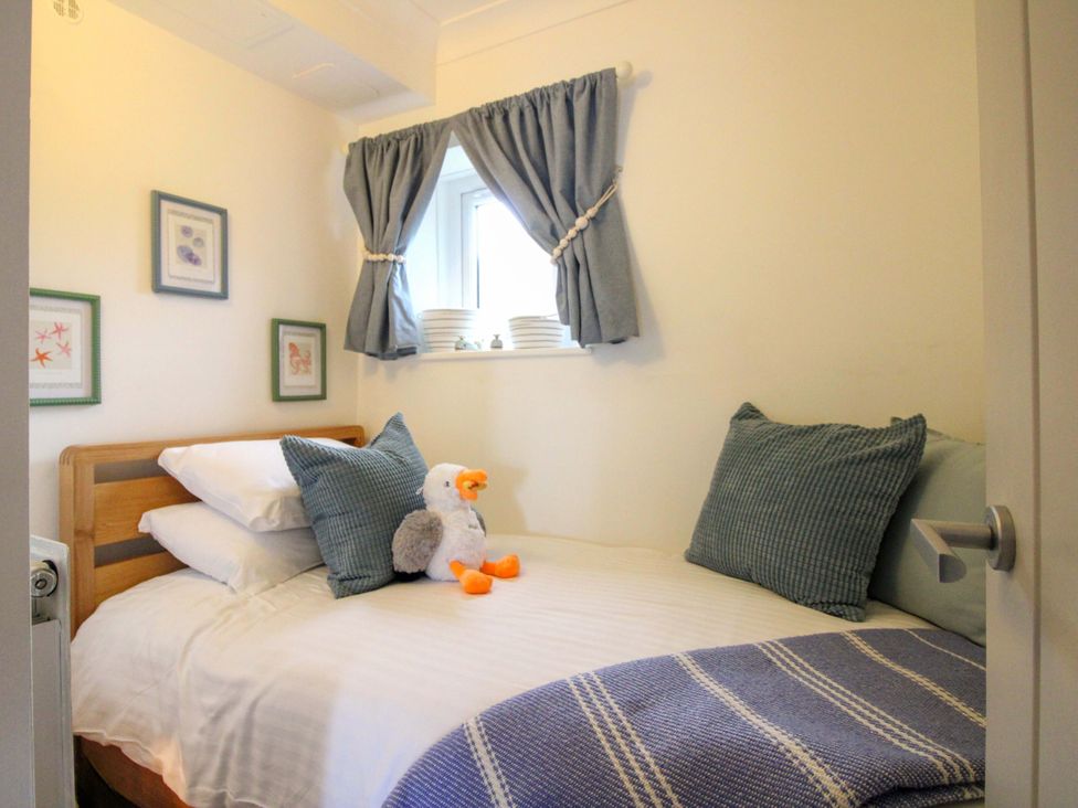 A bedroom with a bed and wall art at 3 The Elms in Salcombe