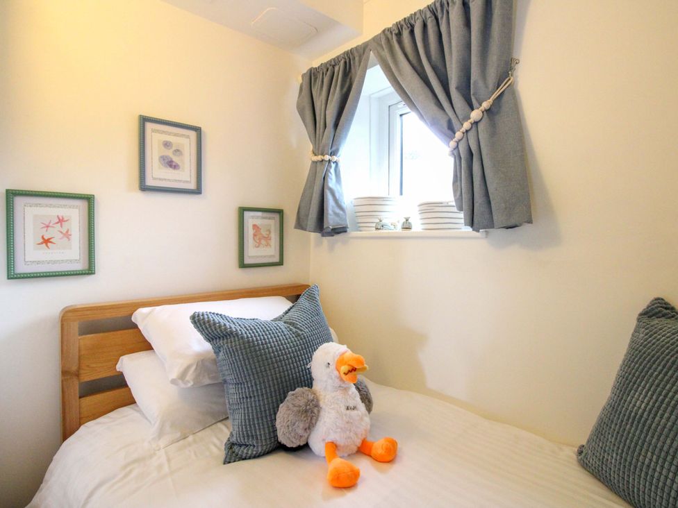 A bedroom with a bed and a stuffed animal at 3 The Elms in Salcombe