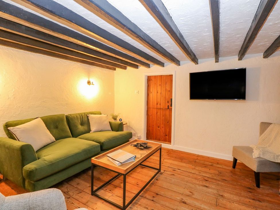 A living room with a sofa and coffee table at Vintner's Cottage in Reedham