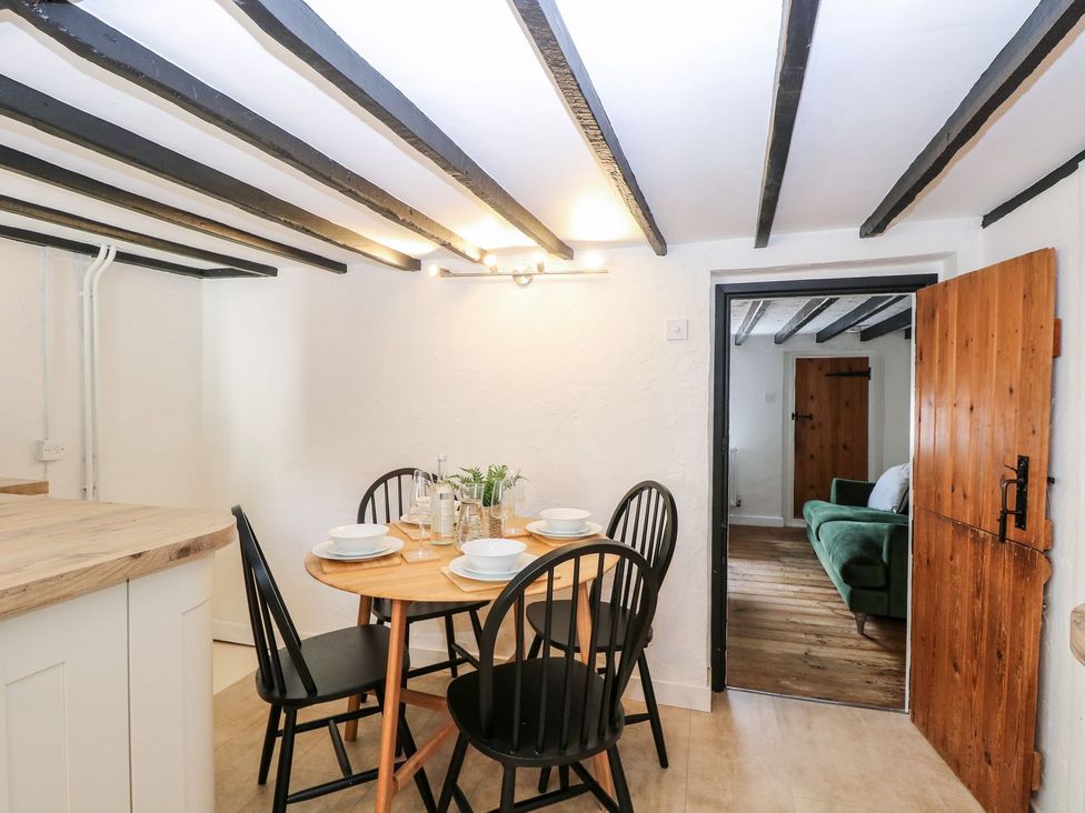 A dining room with a table and chairs at Vintner's Cottage in Reedham