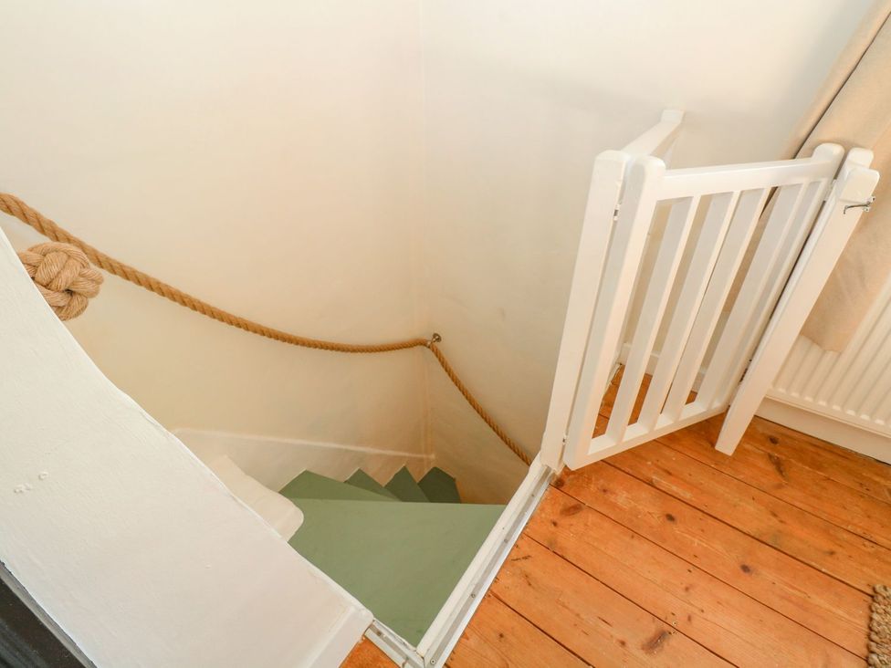 A staircase with a gate and rope at Vintner's Cottage Reedham