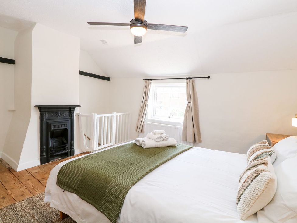 A bedroom with a bed and window at Vintner's Cottage in Reedham