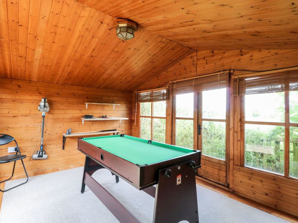 A snug with a pool table and windows at Vintner's Cottage in Reedham