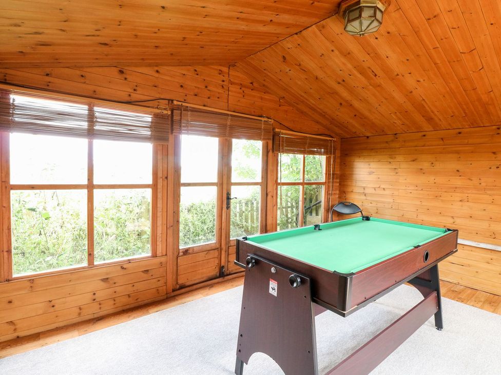 A game room with a pool table and windows at Vintner's Cottage in Reedham