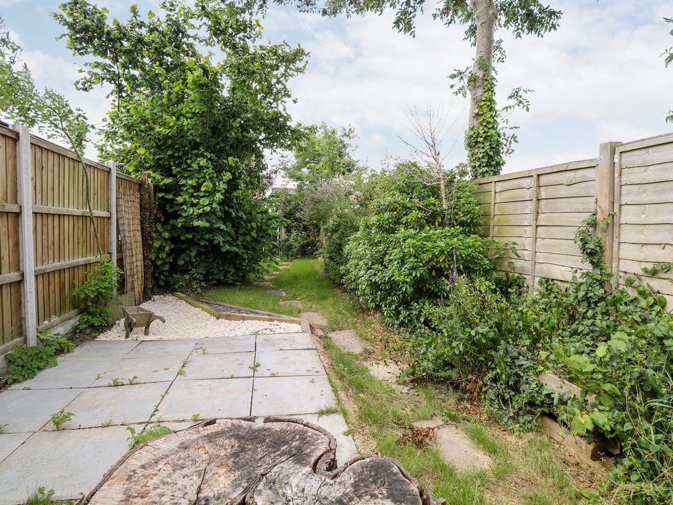 A garden with a path and shrubs at Vintner's Cottage in Reedham
