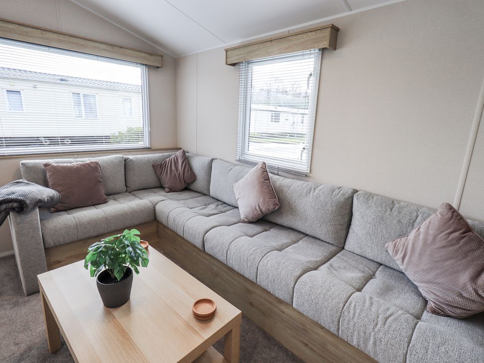 A living room with a sofa and table at Hadrian's Rest in Wigton