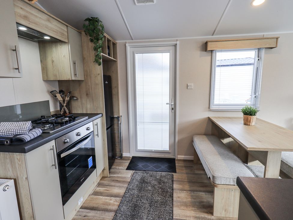 A kitchen with a stove and a table at Hadrian's Rest in Wigton
