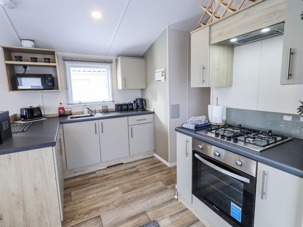A kitchen with cabinets and appliances at Hadrian's Rest in Wigton