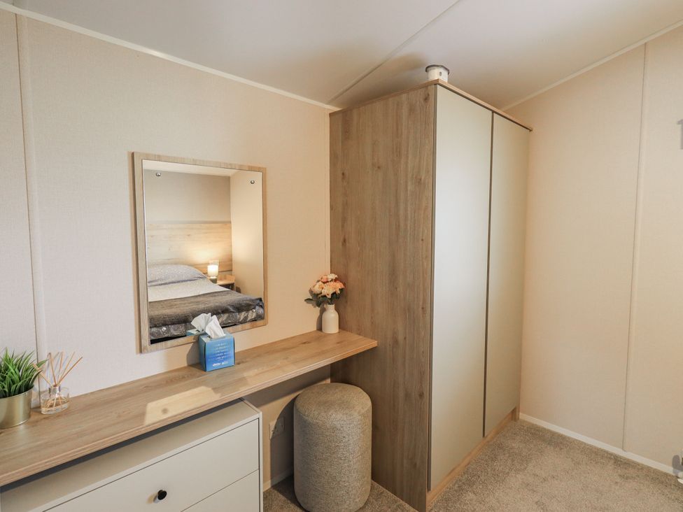 A bedroom with a mirror and wardrobe at Hadrian's Rest in Wigton