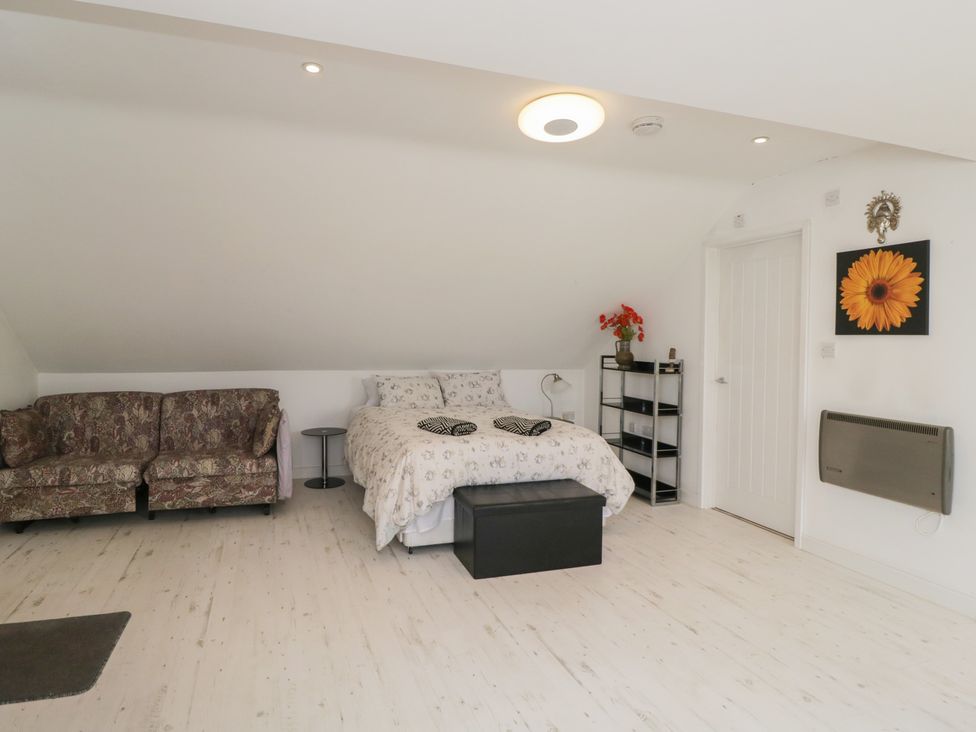 A bedroom with a bed and sofa at The Nest in Meare near Glastonbury