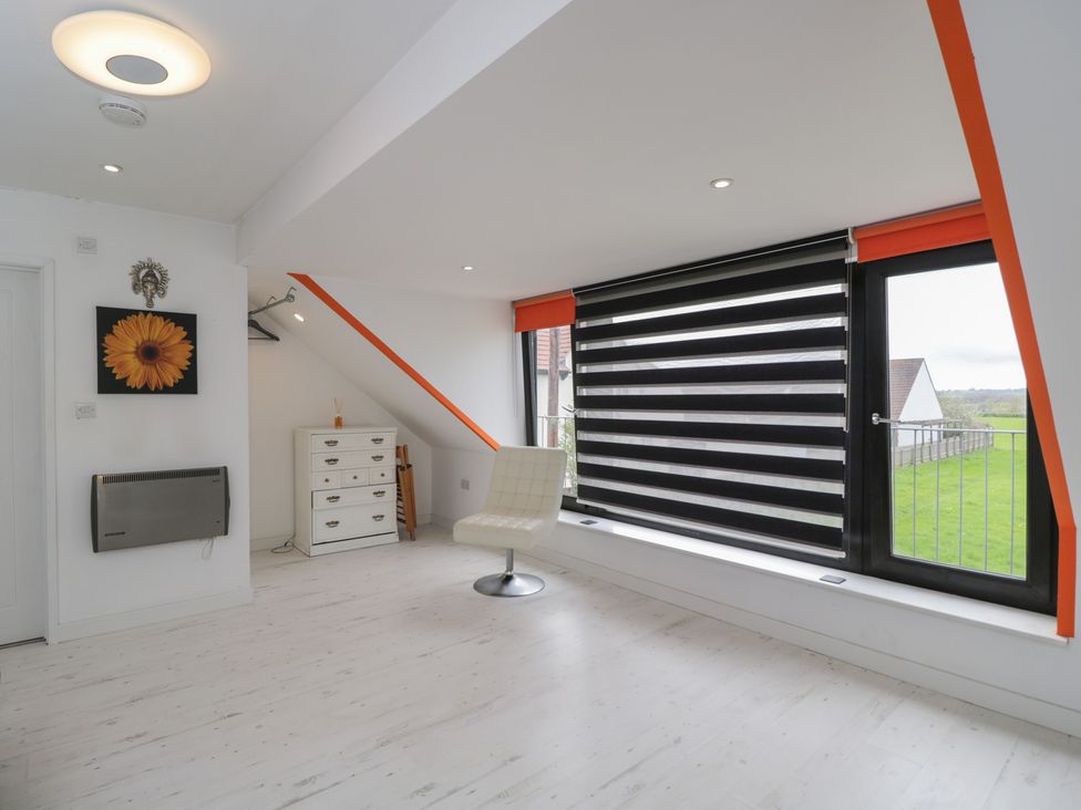 A room with a chair and window at The Nest near Glastonbury