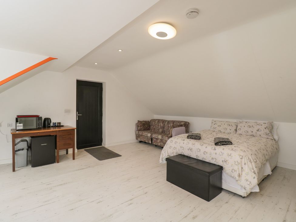 A bedroom with a bed and sofa at The Nest in Meare near Glastonbury