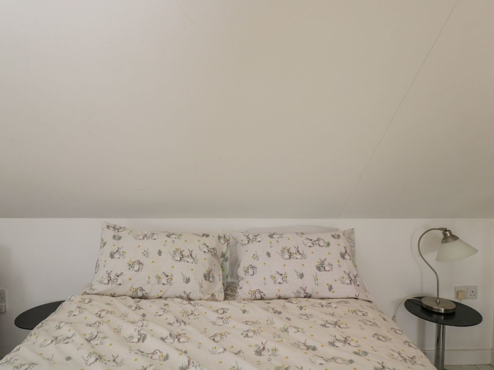 A bedroom with a bed and bedside lamp at The Nest in Meare near Glastonbury