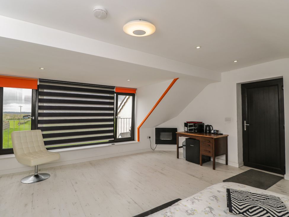 A bedroom with a chair and coffee maker at The Nest in Meare near Glastonbury