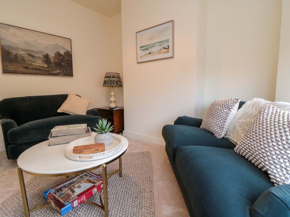 A living room with a sofa, coffee table, and lamp at No.9 Trafalgar St West, Scarborough
