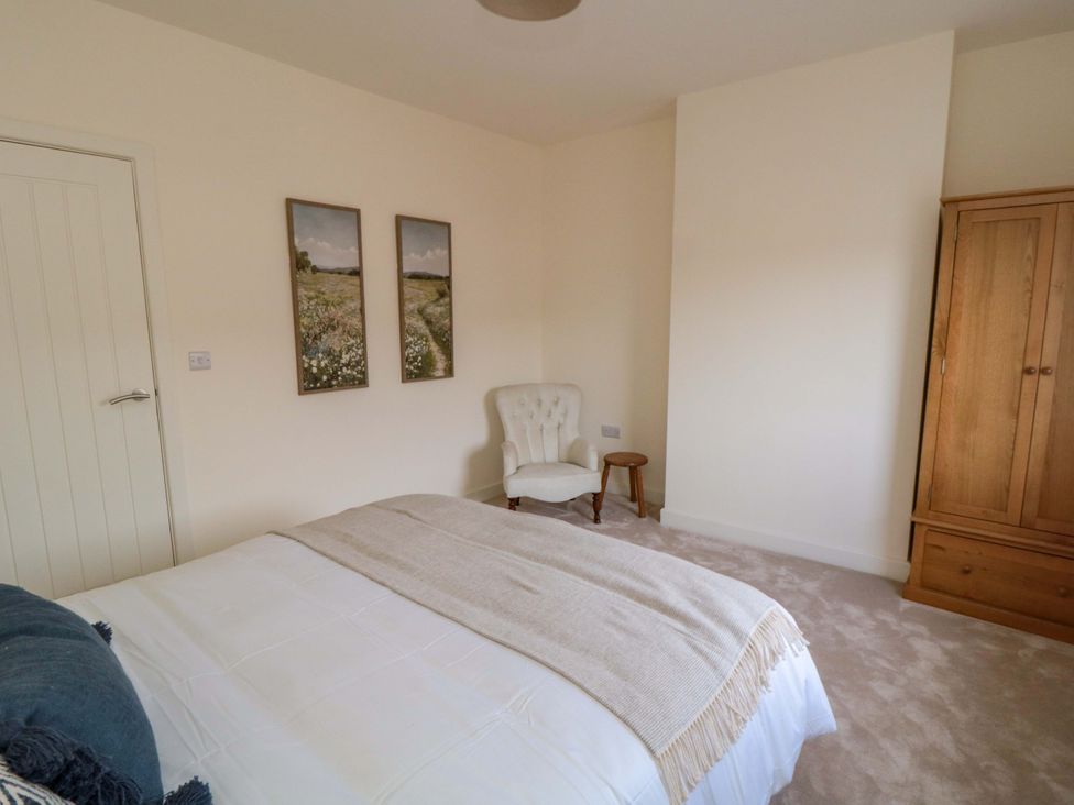A bedroom with a bed, chair, and wardrobe at No.9 Trafalgar St West, Scarborough