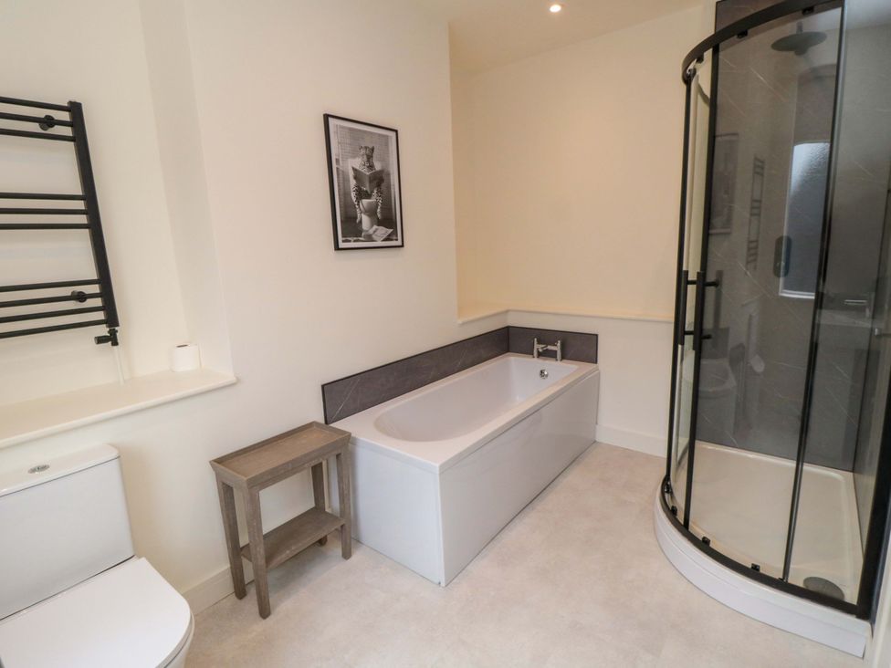 A bathroom with a bathtub, shower, toilet, and towel rail at No.9 Trafalgar St West, Scarborough