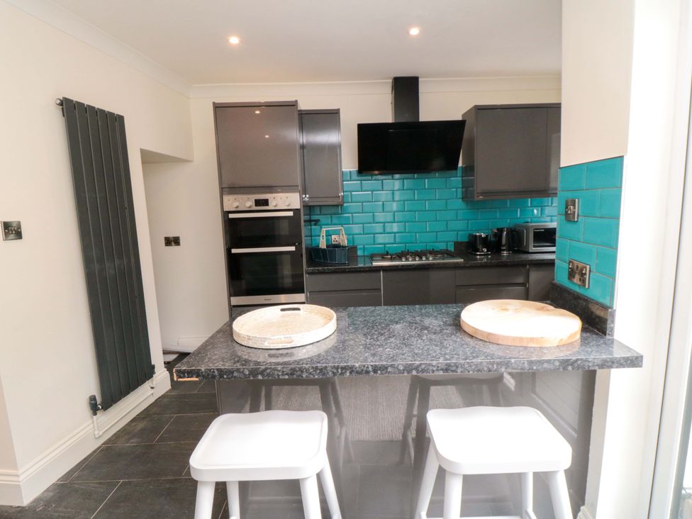 A kitchen with a countertop and bar stools at No.8 Trafalgar St West in Scarborough