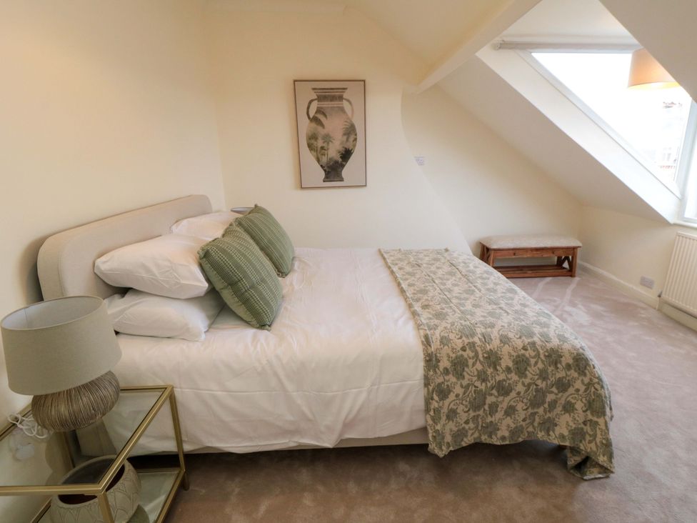 A bedroom with a bed, lamp, and nightstand at No.8 Trafalgar St West Scarborough
