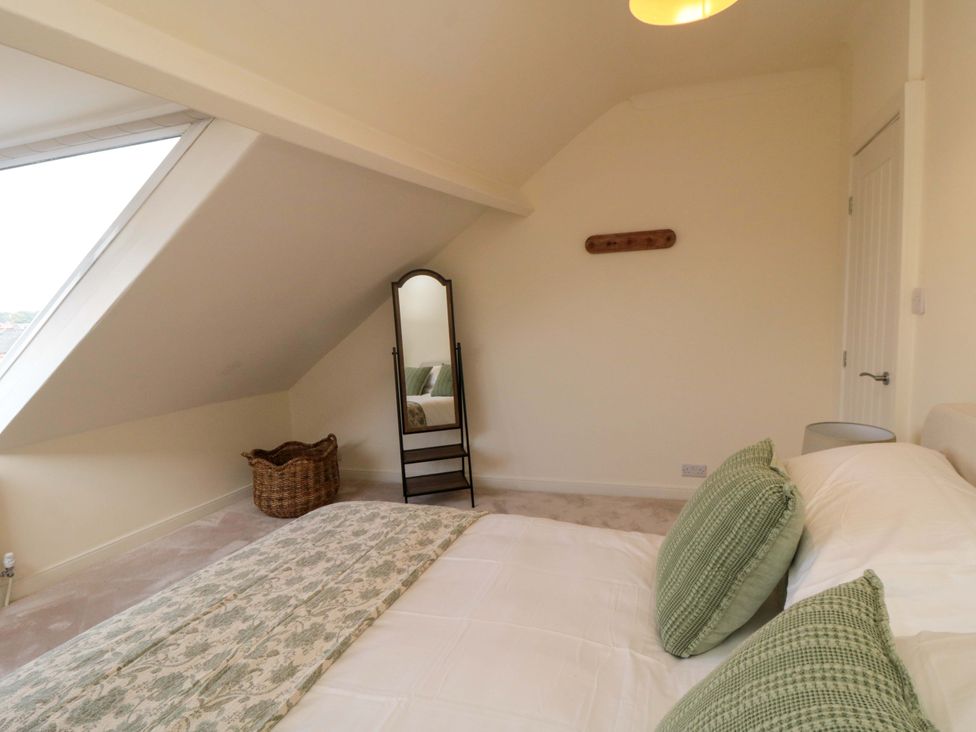 A bedroom with a bed and mirror at No.8 Trafalgar St West Scarborough