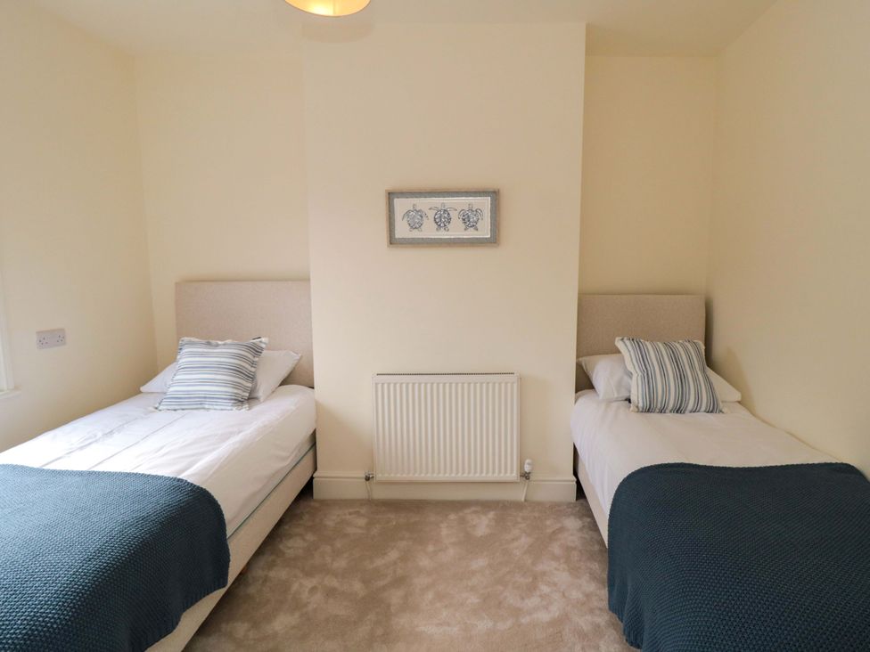A bedroom with two single beds and a radiator at No.8 Trafalgar St West Scarborough