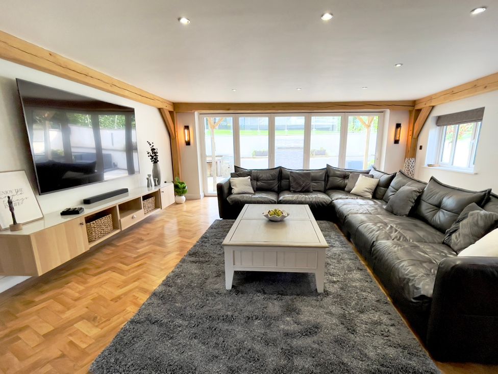 A living room with a large sofa and coffee table at The Oaks in Great Harwood