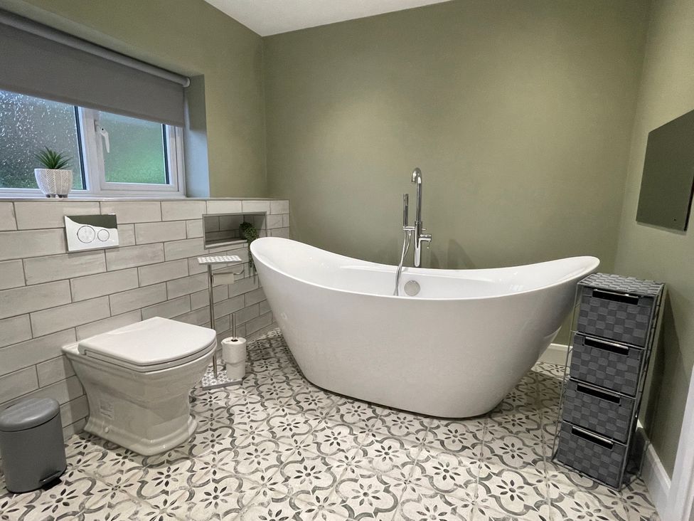 A bathroom with a bathtub and toilet at The Oaks in Great Harwood