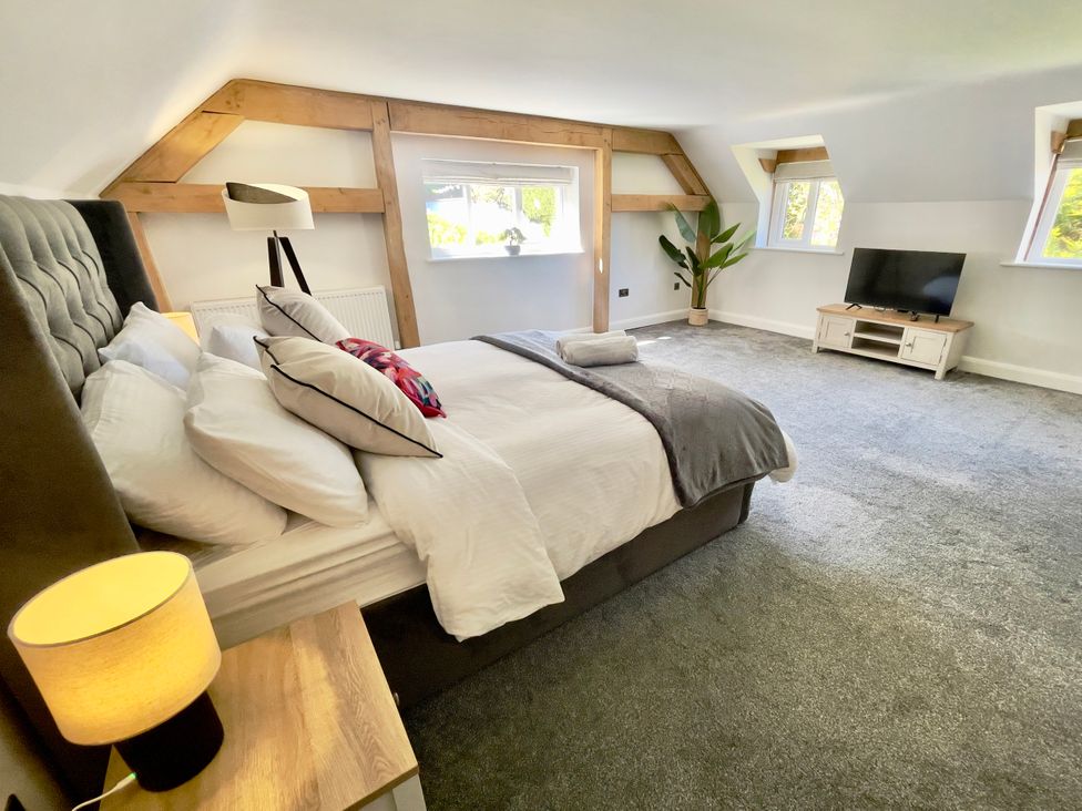 A bedroom with a bed, television and windows at The Oaks in Great Harwood
