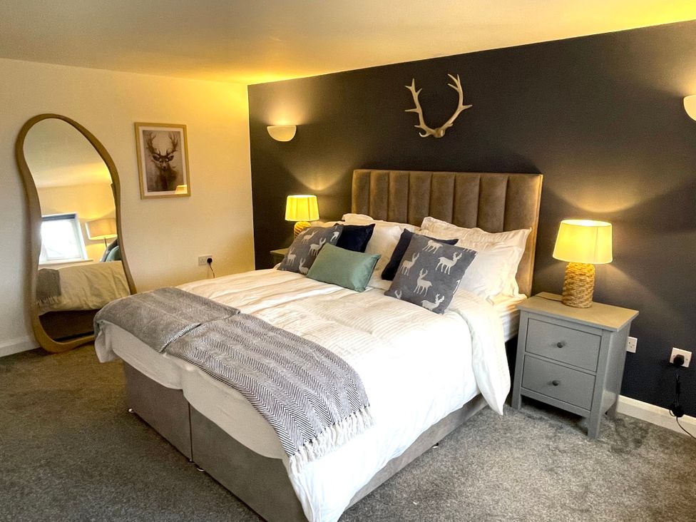 A bedroom with a bed and mirror at The Oaks in Great Harwood
