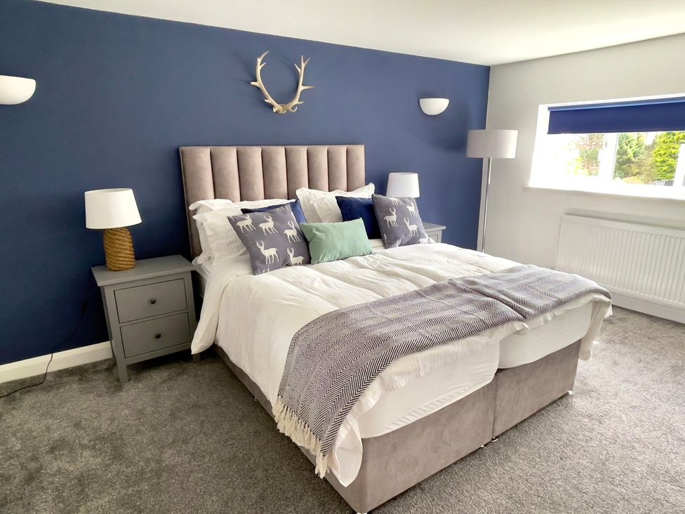A bedroom with a bed and nightstand at The Oaks in Great Harwood