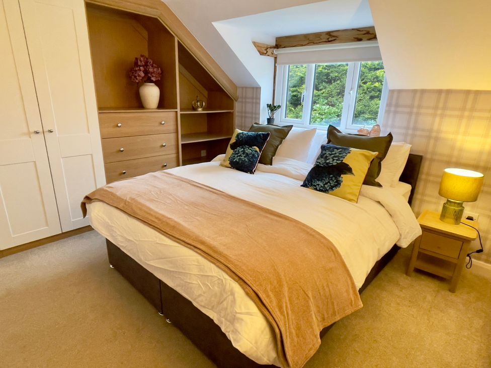 A bedroom with a bed and wardrobe at The Oaks in Great Harwood