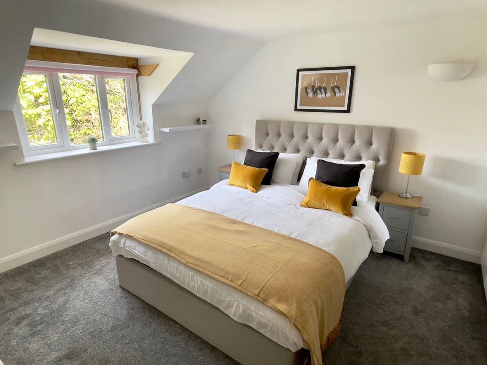 A bedroom with a bed and nightstand at The Oaks in Great Harwood
