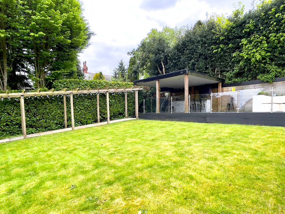 A garden with grass and outdoor seating area at The Oaks in Great Harwood