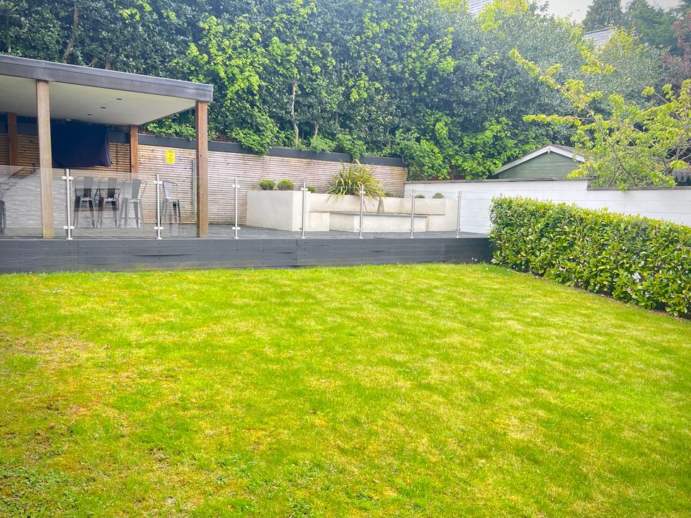 A garden with a deck and grass area at The Oaks in Great Harwood