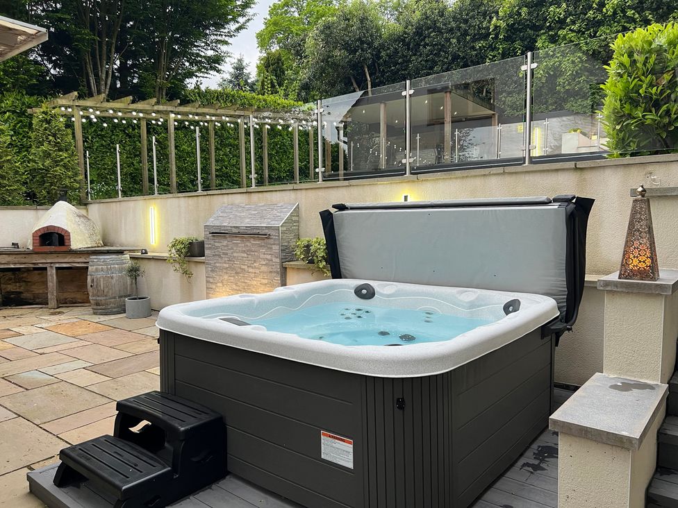An outdoor space with a hot tub and an outdoor oven at The Oaks in Great Harwood
