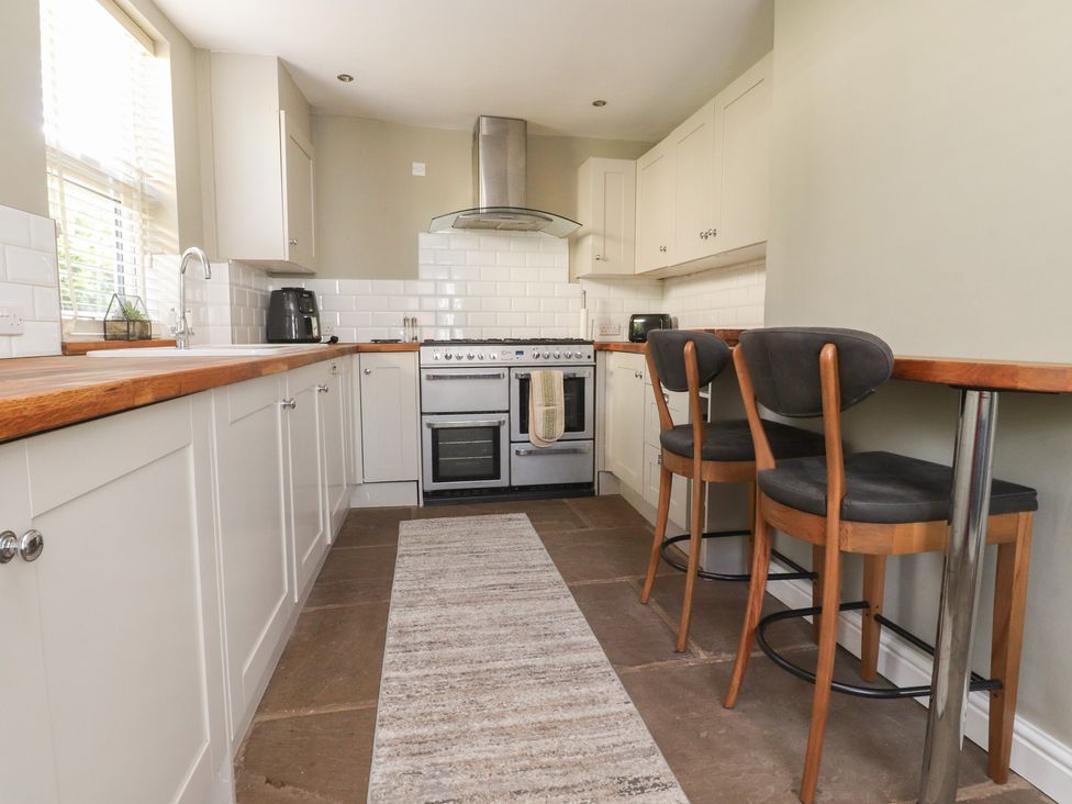 A kitchen with cabinets and bar stools at 47 Grape Lane Croston