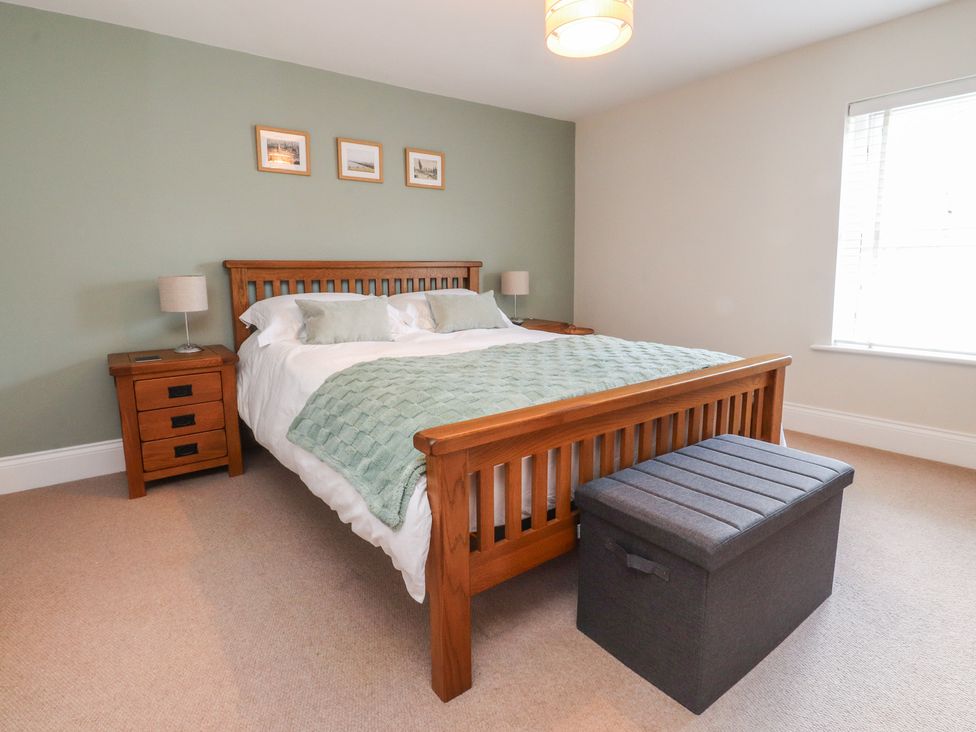 A bedroom with a bed and a storage ottoman at 47 Grape Lane in Croston
