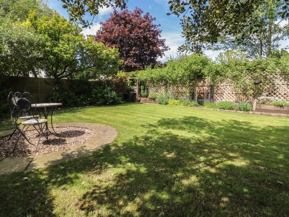 A garden with a table and chair at 47 Grape Lane in Croston