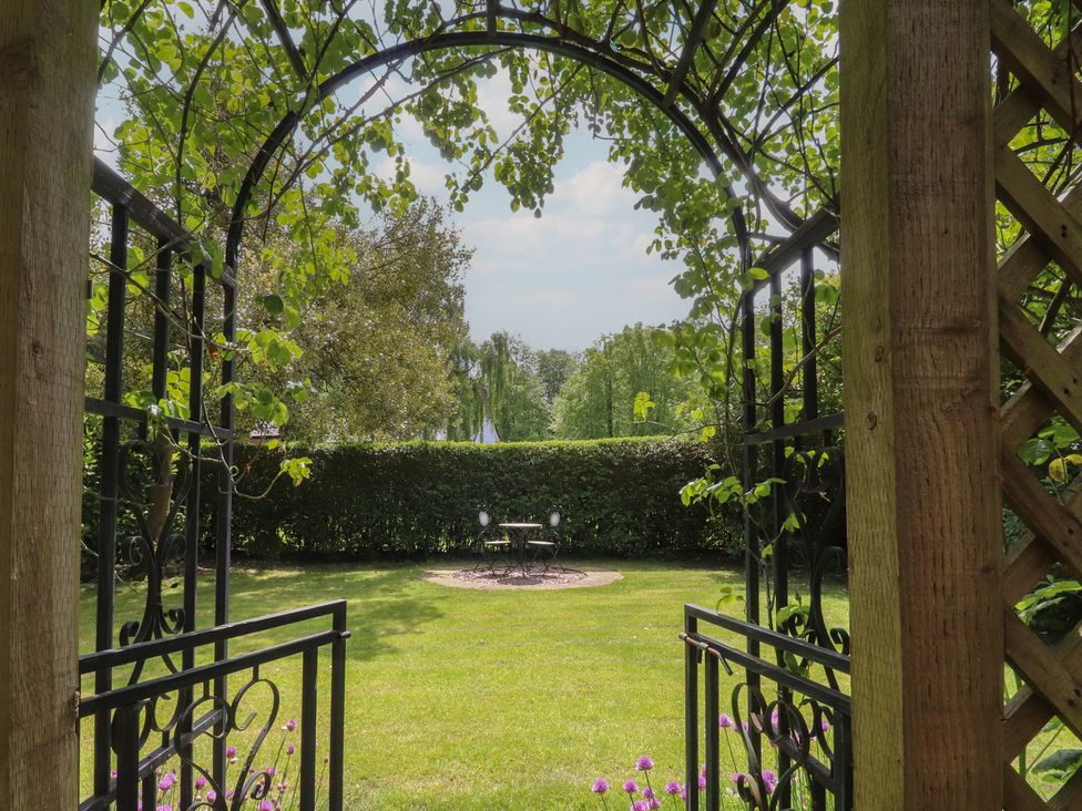 A garden view through an archway at 47 Grape Lane in Croston