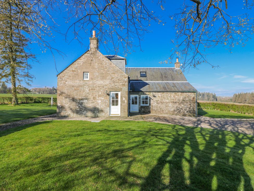 A house with a yard and surrounding trees at Meadowgreen Farmhouse in Forfar