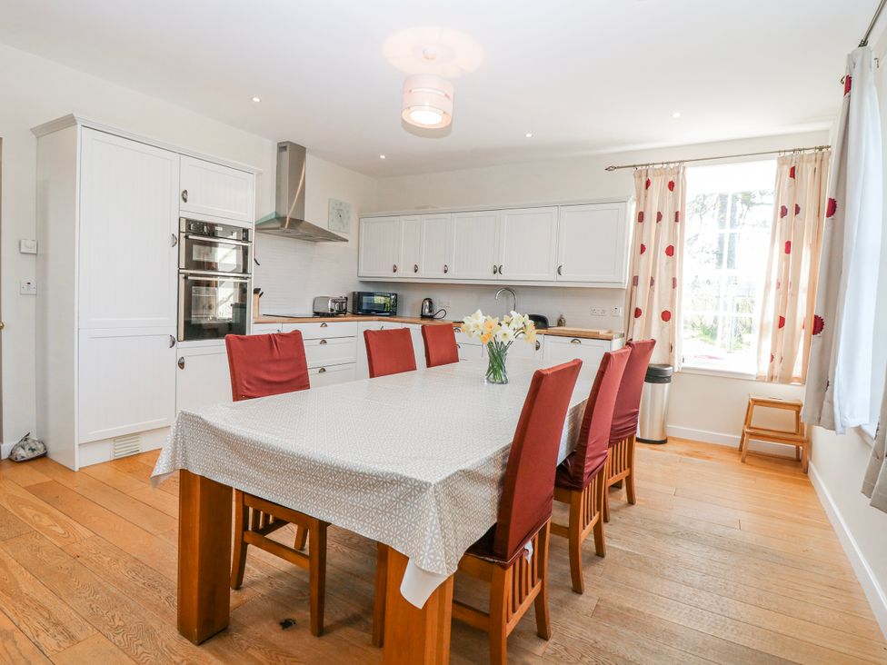 A kitchen with a dining table and chairs at Meadowgreen Farmhouse in Forfar
