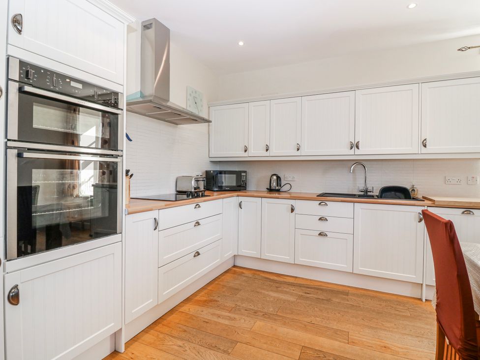A kitchen with appliances and cabinets at Meadowgreen Farmhouse Forfar