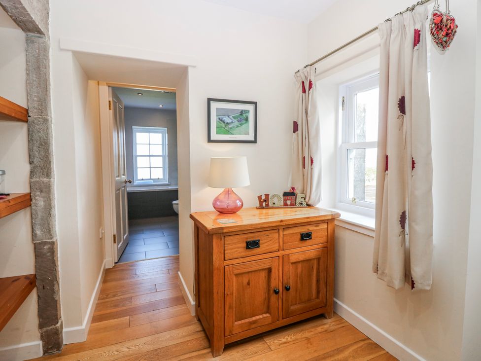 A hallway with a cabinet and window at Meadowgreen Farmhouse in Forfar