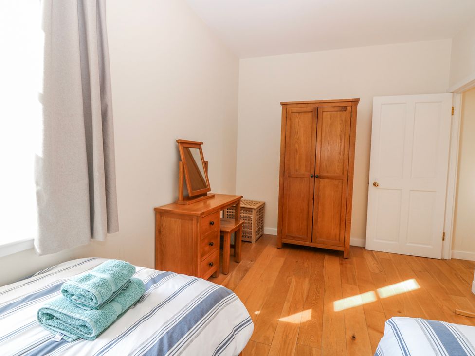A bedroom with a bed and a desk at Meadowgreen Farmhouse in Forfar