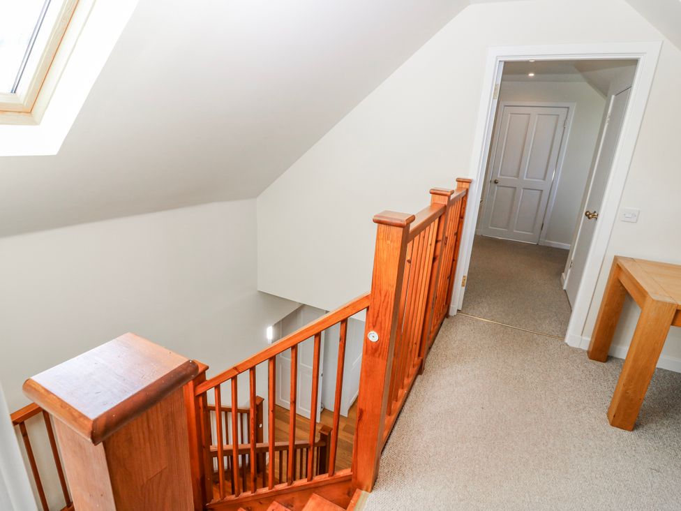 A staircase and hallway with wooden railing at Meadowgreen Farmhouse in Forfar