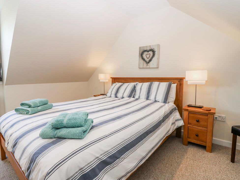 A bedroom with a bed and bedside tables at Meadowgreen Farmhouse in Forfar