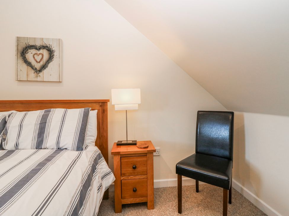 A bedroom with a bed, nightstand and lamp at Meadowgreen Farmhouse in Forfar