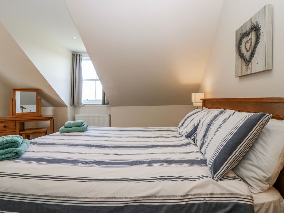 A bedroom with a bed and mirror at Meadowgreen Farmhouse in Forfar