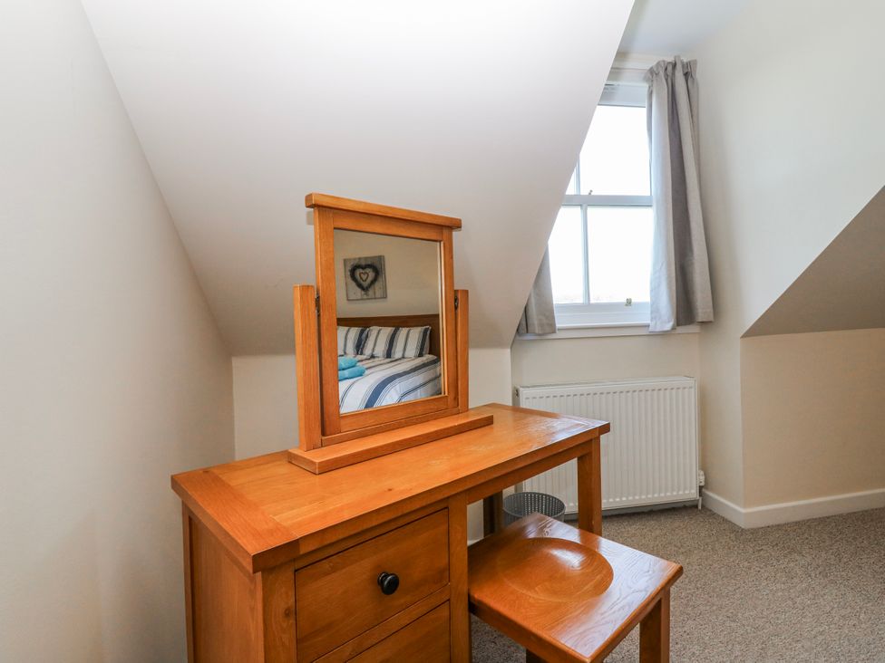 A vanity table with a mirror in a bedroom at Meadowgreen Farmhouse in Forfar