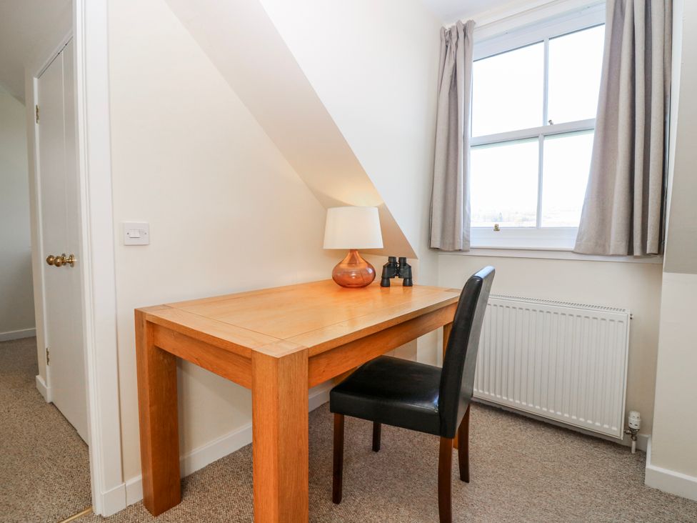 A desk with a lamp and binoculars at Meadowgreen Farmhouse in Forfar